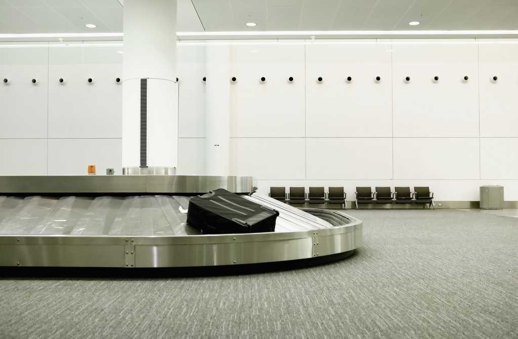 one lonely piece of luggage on an airport carousel. 93366961