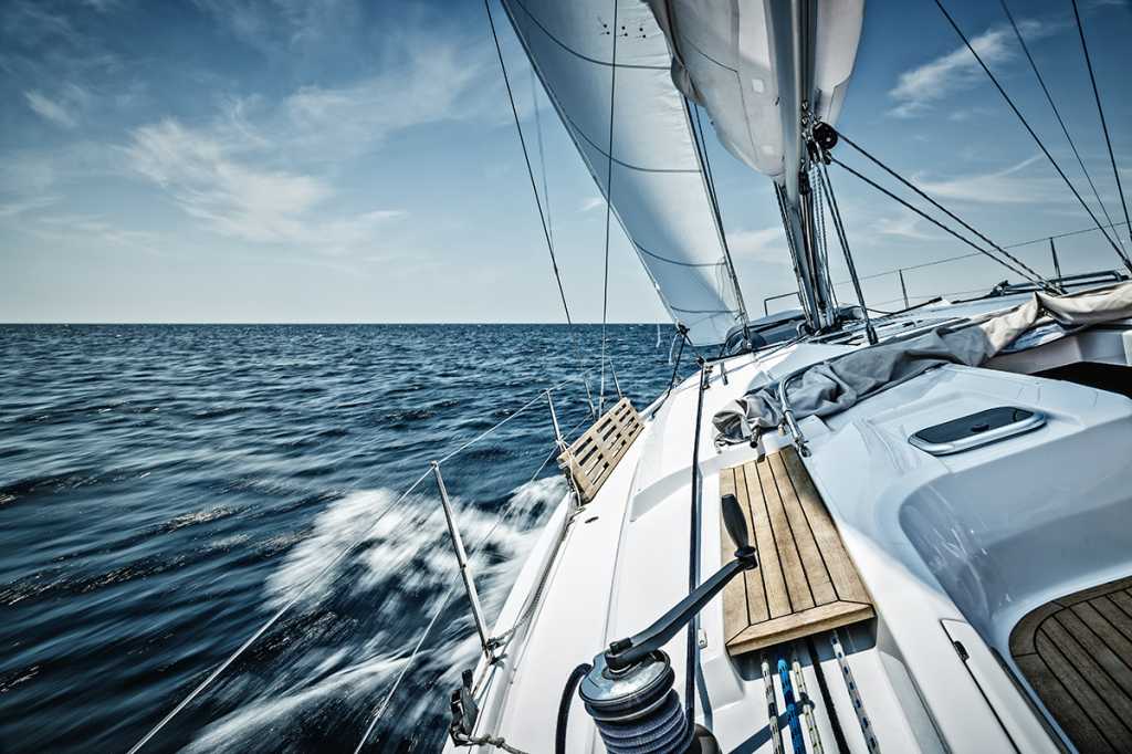 Perspective shot of a sailboat moving quickly through the open ocean.